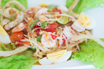 Papaya salad with shrimps and boiled egg on top .Thai cuisine spicy SOM TAM,famous food in Thailand.