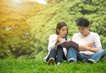 Naklejka na ściany i meble Relaxing and enjoy young asian couple reading book together