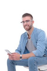 Young man sitting on chair and using mobile phone. Startupper. Young entrepreneur.