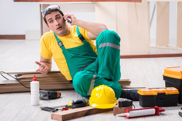 Contractor working on laminate wooden floor 