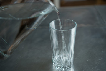 pouring water from a pitcher into a glass