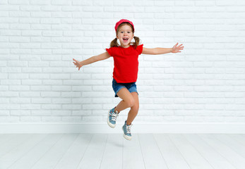 happy child girl jumping around empty wall