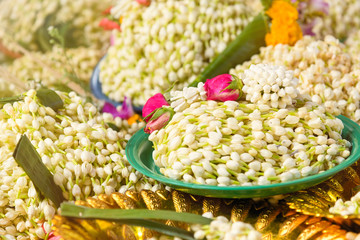 A lot of jasmin garland on a tray consecrated Buddha inside the temple.Thailand.