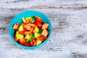 fresh summer organic salad with tomatoes cucumbers on wooden table