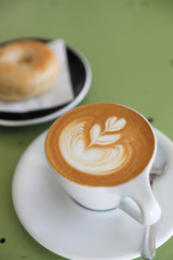 Cappuccino coffee break on wood background with bagel