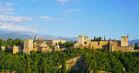 Fototapeta na wymiar The Alhambra palace and fortress at sunrise hour, Granada, Spain. Ancient Arabic fortress with Sierra Nevada mountains on horizon in Andalusia, South Spain.
