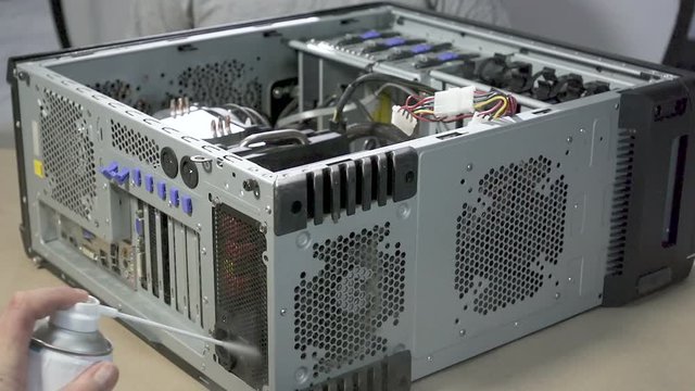 Cleaning Computer With Compressed Air.Serviing a Computer equipment with Dust-Off Disposable Compressed Gas Duster, canned air..Removing dust from hard-to-reach places in PC
