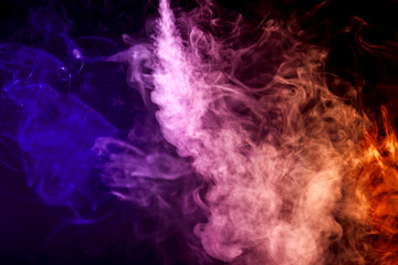 Thick colorful smoke of purple, lilac, orange  colors on a black isolated background. Background from the smoke of vape