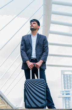 Business man standing at outdoors with luggage in the routine of working with determination and confidence. concept of business trip travel and transportation.