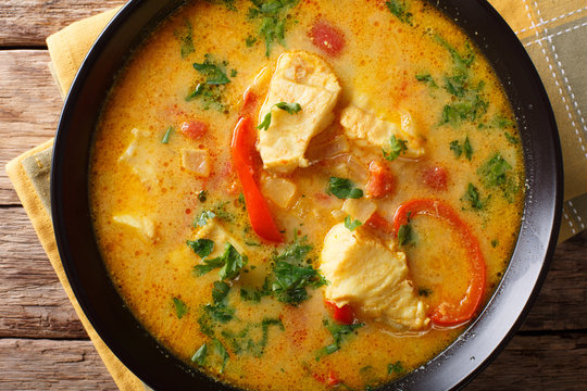 traditional Brazilian dish Moqueca Baiana of fish and bell peppers in a delicately coconut sauce close-up. horizontal top view