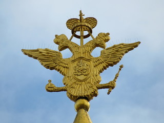 Fototapeta na wymiar Golden double-headed eagle over the building of the Historical Museum in Moscow. The national emblem of Russia on the background of blue sky