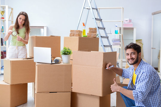 Young family unpacking at new house with boxes