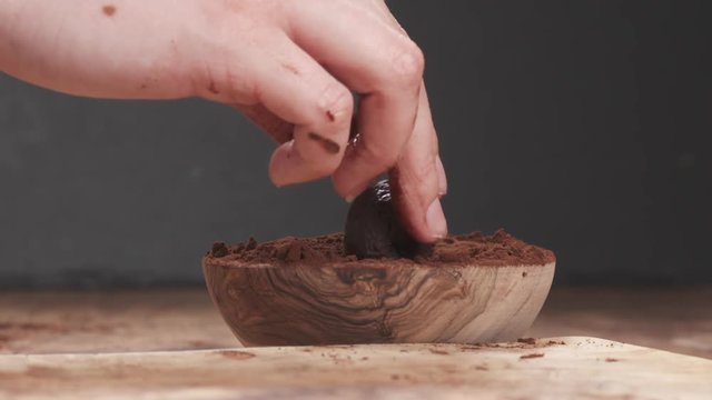 Slow motion put truffles in cocoa powder
