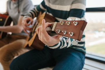Fototapeta premium Learning to play the guitar. Music education and extracurricular lessons. Hobbies and enthusiasm for playing guitar and singing songs.