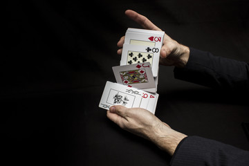 Man's hands with playing cards. Black background