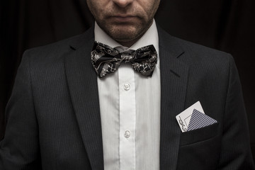 Man with playing cards in suit with bow tie