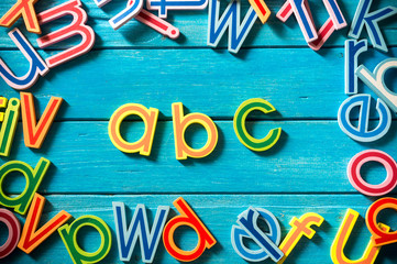 Close up arrangement of "ABC" alphabet on blue background. Preschool, education concept or other your content. Long shadow and vignette effect.