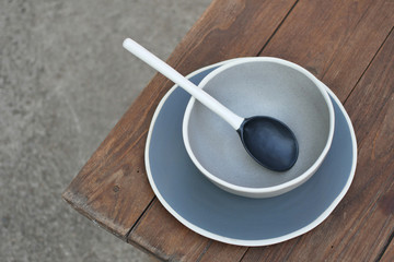 Bowls and Ceramic Spoons on Wooden background