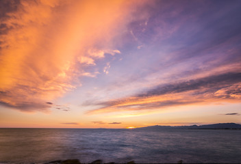 Fototapeta na wymiar Colorful dark sunset over the sea and mountains