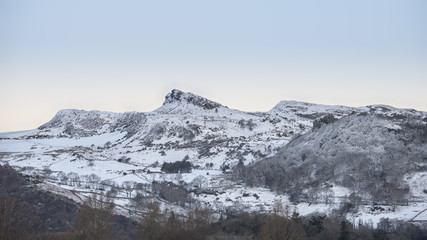 Fototapeta premium Beautiful Winter sunrise landscape image of Mount Snowdon and other peaks in Snowdonia National Park