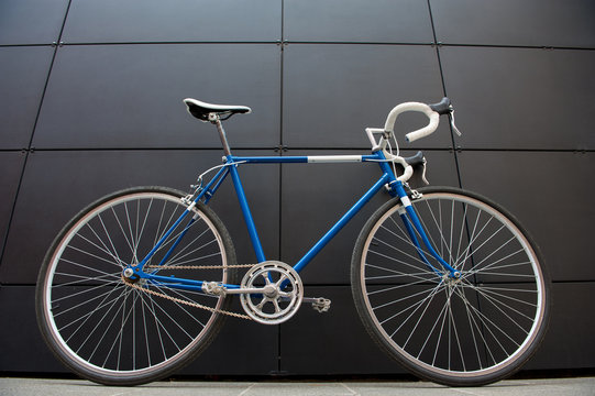 Vintage blue city bicycle against a black wall