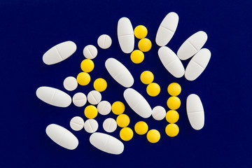 Pile of pills on blue background.