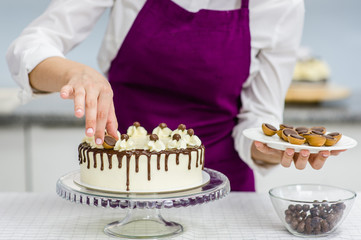 woman decorating chocolate cake in the kitchen