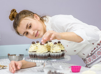 Young woman decorates cupcakes