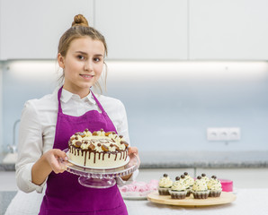 Woman holding a cake with the inscription "open". The concept of opening a small business. Space for text