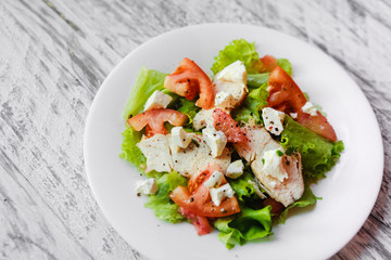 cooking a healthy fresh salad with chicken, grapefruit, cheese and tomatoes