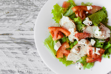 cooking a healthy fresh salad with chicken, grapefruit, cheese and tomatoes