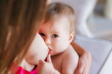 Mother breast feeding her little baby. Close-up shot, focus on face