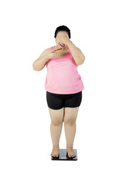 Obese woman standing on the weighing scale