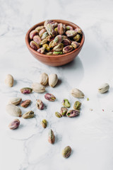 Roasted and salted pistachios nuts on marble background