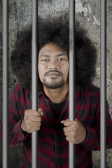 Male drunkard standing in the jail
