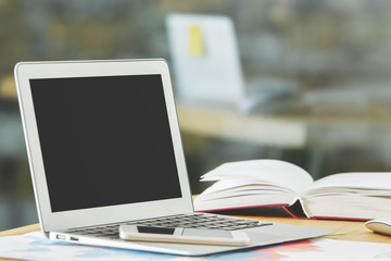 Modern table with empty white laptop