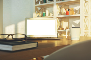 Bright table with empty laptop