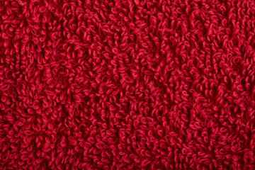 red fabric and texture concept - close up of a towel terrycloth or terry textile background