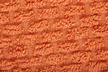 orange fabric and texture concept - close up of a towel terry cloth or terry textile background