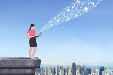 Beautiful businesswoman with laptop on the rooftop