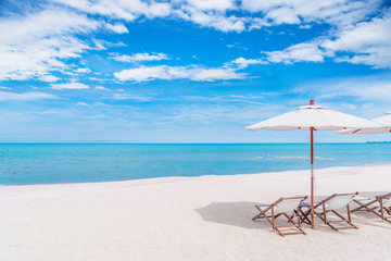 Beach chair with white umbrella tropical beach in summer with blue sky background, Vacation and travel concept..