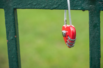 cadenas rouge en forme de coeur attaché à une grille