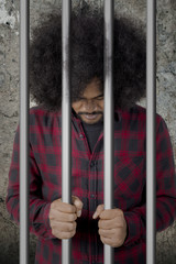 Afro man looks desperate in the jail