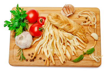 Smoked braided cheese and vegetables on white background