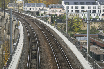 Detail of electrical railroad in Luxembourg city with rails, contact lines and viaduct structures in dark autumn day illustrating urban transport concept, Luxembourg.