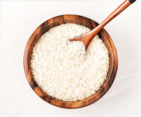 Fototapeta na wymiar Isolated handful of raw rice in the wood bowl on white background