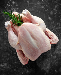 Whole raw Free range chicken in rustic background with rosemary leaf. ready to cook