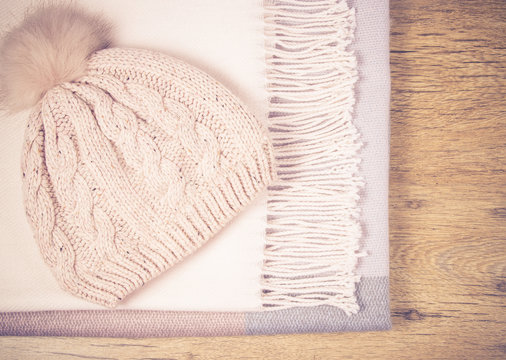 Warm winter knitted clothes on a wooden background.