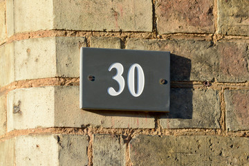 House number 30 sign fixed to wall