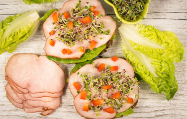 Sandwiches with lettuce, ham and broccoli sprouts.